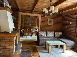een woonkamer met een bank en een tafel bij Leśna Chatka nad Jeziorem Gim na Mazurach in Teerau