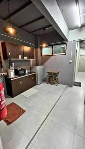 eine große Küche mit einem Tisch und einem Kühlschrank in der Unterkunft BRICKS Cameron Hostel in Tanah Rata