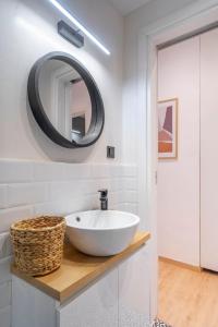 een badkamer met een witte wastafel en een spiegel bij Modern flat in Kolonaki in Athene