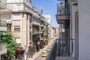 een uitzicht op een straat met auto's en gebouwen bij Modern flat in Kolonaki in Athene