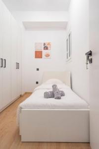 een slaapkamer met een wit bed met een knuffeldier erop bij Modern flat in Kolonaki in Athene
