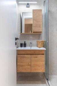 een badkamer met een wastafel en een spiegel bij Modern flat in Kolonaki in Athene