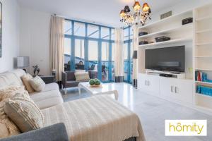 een woonkamer met een bank en een tv bij Exclusive Castell de Ferro - Castell Playa in Castell de Ferro