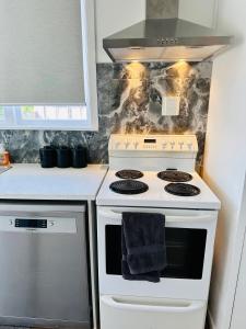 a kitchen with a white stove with a towel on it at Spacious 4 bedroom House in Manukau in Auckland +14 photos