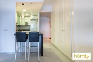a kitchen with a table and two blue chairs at Exclusive Castell de Ferro - Castell Playa in Castell de Ferro