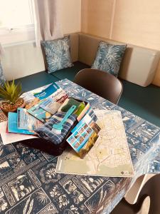 a table with books and magazines on top of it at Mobilhome P27 6 personnes climatisé in Le Portel