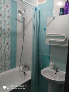 a bathroom with a shower curtain and a sink at Elena in Rivne