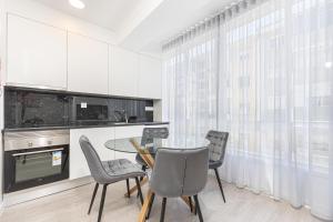 a kitchen with a dining room table and chairs at Príncipe Apartamentos e Suites in Lisbon