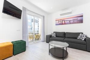 uma sala de estar com um sofá e uma mesa em Príncipe Apartamentos e Suites em Lisboa