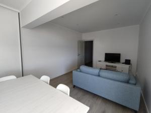 アルマカオ・デ・ペラにある8-2 Torre Sol - Casas & Papéisのリビングルーム(青いソファ、テレビ付)