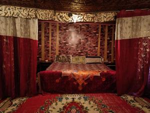 1 dormitorio con 1 cama en una habitación con cortinas rojas en Island, en Srinagar