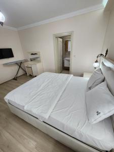 فندق إيسا سويت  في طرابزون: سرير أبيض كبير في غرفة نوم بيضاء
