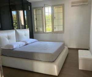 a white bed in a room with two windows at Villa Rachele con piscina in Balestrate +64 photos