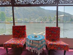 two chairs and a table with a view of the water at Island in Srinagar