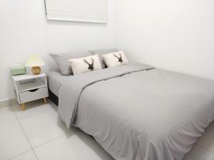 Habitación blanca con cama y mesita de noche en Greenfield Residence Bandar Sunway Petaling Jaya en Petaling Jaya