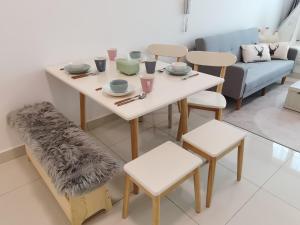 a dining room with a table and chairs and a couch at Greenfield Residence Bandar Sunway Petaling Jaya in Petaling Jaya