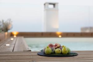 einen Obstteller auf einem Tisch neben einem Pool in der Unterkunft Porta Vetere - Boutique Rooms in Trani