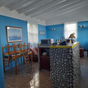 ein Wohnzimmer mit blauen Wänden und einer Steintheke in der Unterkunft Canefield sea view apartment in Roger