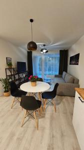 een woonkamer met een tafel en stoelen en een bank bij 2 room Apartment with terrace, new building, 2BK in Bratislava