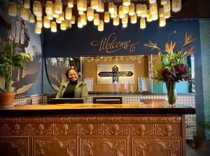 a woman standing behind a counter with a laptop at Bannister Hotel in Johannesburg