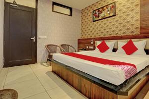 una camera da letto con un grande letto con cuscini rossi di OYO Flagship 81231 Hotel Seven a Ludhiana