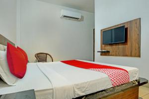 a bedroom with a bed with a tv on the wall at OYO Flagship 81231 Hotel Seven in Ludhiana