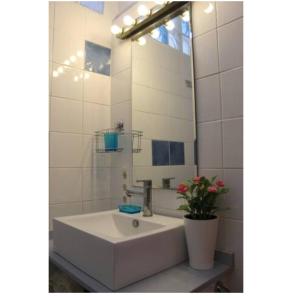 La salle de bains blanche est pourvue d'un lavabo et d'un miroir. dans l'établissement Habitación en piso compartido Room in shared flat, à Torremolinos