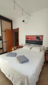 - une chambre avec un grand lit blanc et 2 serviettes dans l'établissement Habitación en piso compartido Room in shared flat, à Torremolinos