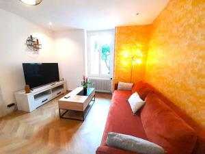 een woonkamer met een rode bank en een flatscreen-tv bij Élégante maison avec patio Vatan Centre in Vatan