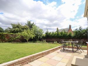 a patio with a table and chairs in a yard at Joray Bungalow in Alford