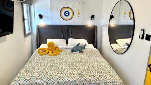 Dormitorio con cama con espejo y animales de peluche en GW317 Gugel Waves Amazing Seaview Pool Apartments, en Nahariyya