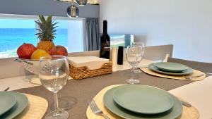 una mesa con platos y vasos y una cesta de fruta en GW317 Gugel Waves Amazing Seaview Pool Apartments, en Nahariyya