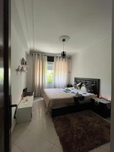 a bedroom with a large bed and a window at Tanger , Merchan in Tangier