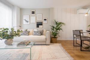 Miosotis Suites في مدريد: غرفة معيشة مع أريكة وطاولة