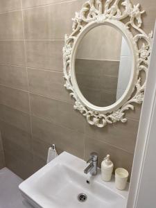 baño con lavabo y espejo en la pared en Home Apartments en Seline