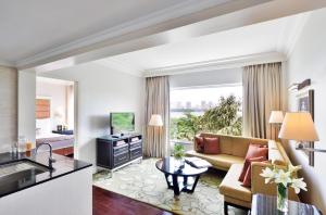 a living room with a couch and a television at Marriott Executive Apartment - Lakeside Chalet, Mumbai in Mumbai