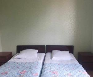 2 Betten mit weißen Kissen nebeneinander sitzen in der Unterkunft Guesthouse Luka in Martvili
