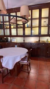 Vall de Bianya的住宿－Hostal de Bianya，厨房配有白色的桌子、椅子和窗户。