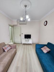 فندق إيسا سويت  في طرابزون: غرفة معيشة بها أريكة زرقاء وتلفزيون
