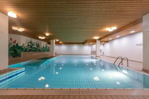 a large indoor swimming pool with blue tile flooring at Esclusivo bilocale centralissimo in St. Moritz
