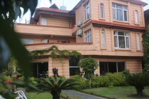 a large building with trees in front of it at Hotel Bedrock in Pokhara