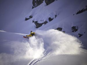 a person is skiing down a snow covered mountain at Nangijala Hostel in Disentis