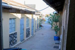 an empty alley with blue and white buildings at Perfect Guest House Kyotera in Kyotera