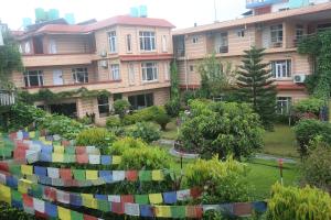 a garden with colorful fence in front of a building at Hotel Bedrock in Pokhara