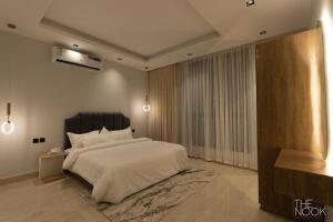 1 dormitorio con 1 cama blanca grande y TV en شقة فخمة 3 غرف نوم في حي الملقا قريبه من البوليفارد The Nook, luxury 3BD Flat in malqa district near BLVD, en Riad