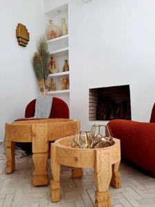 a living room with a red couch and a table at Magnifique Riad Lantau - Authentic & Chic in Marrakesh
