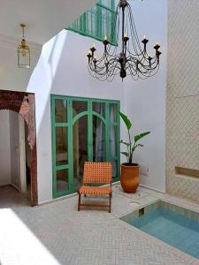a chair sitting next to a building with a chandelier at Magnifique Riad Lantau - Authentic & Chic in Marrakesh