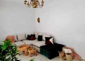 uma sala de estar com um sofá e um lustre em Magnifique Riad Lantau - Authentic & Chic em Marrakech