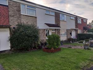 a house with a grass yard in front of it at Spacious Comfortable 4 Bedroom House! in Aylesbury