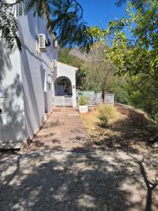 una pasarela que conduce a un edificio blanco con una puerta en casa bonita deluxe suite, en Mijas